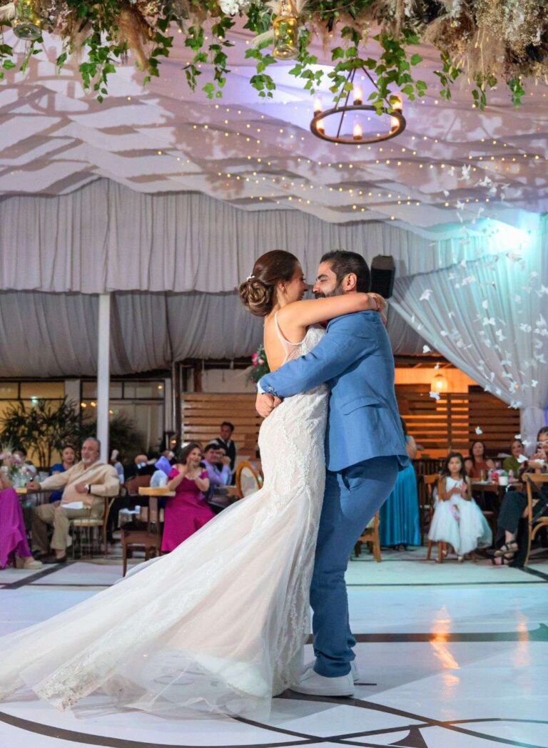 Novios bailando en pista iluminada durante recepción en Jardín Allegra 55