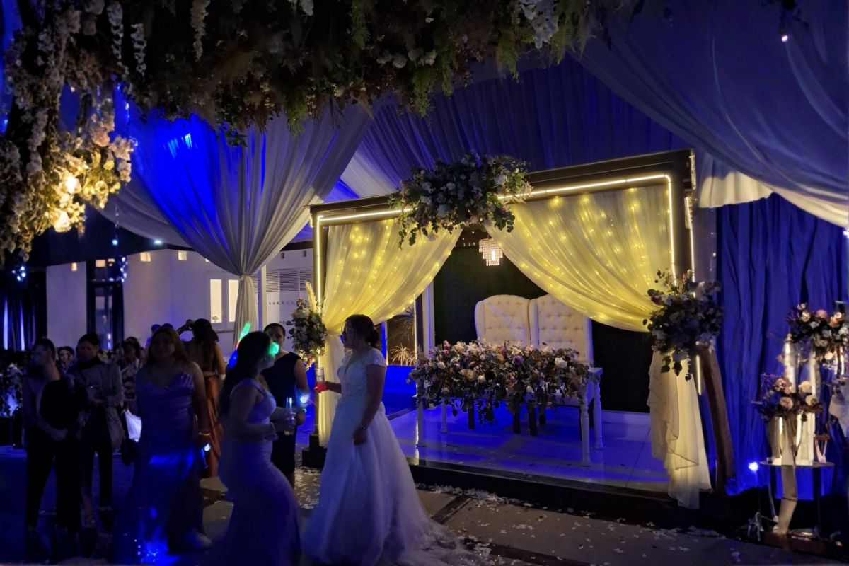 Mesa de novios decorada con flores y luces cálidas durante boda nocturna en Jardín Allegra 55.