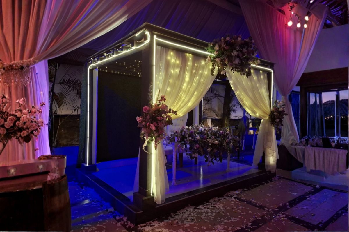 Pérgola de novios con iluminación rosa en boda nocturna en Jardín Allegra 55.