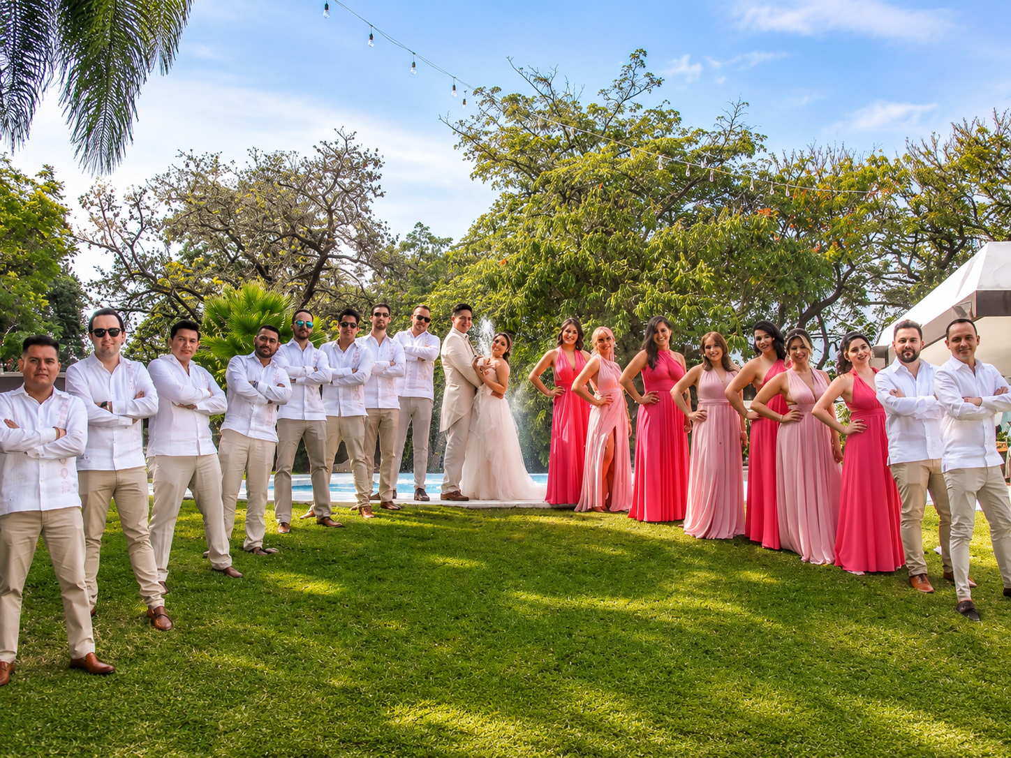 Novios con padrinos y madrinas en el jardín junto a la alberca en una boda en Jardín Allegra 55, Cuernavaca