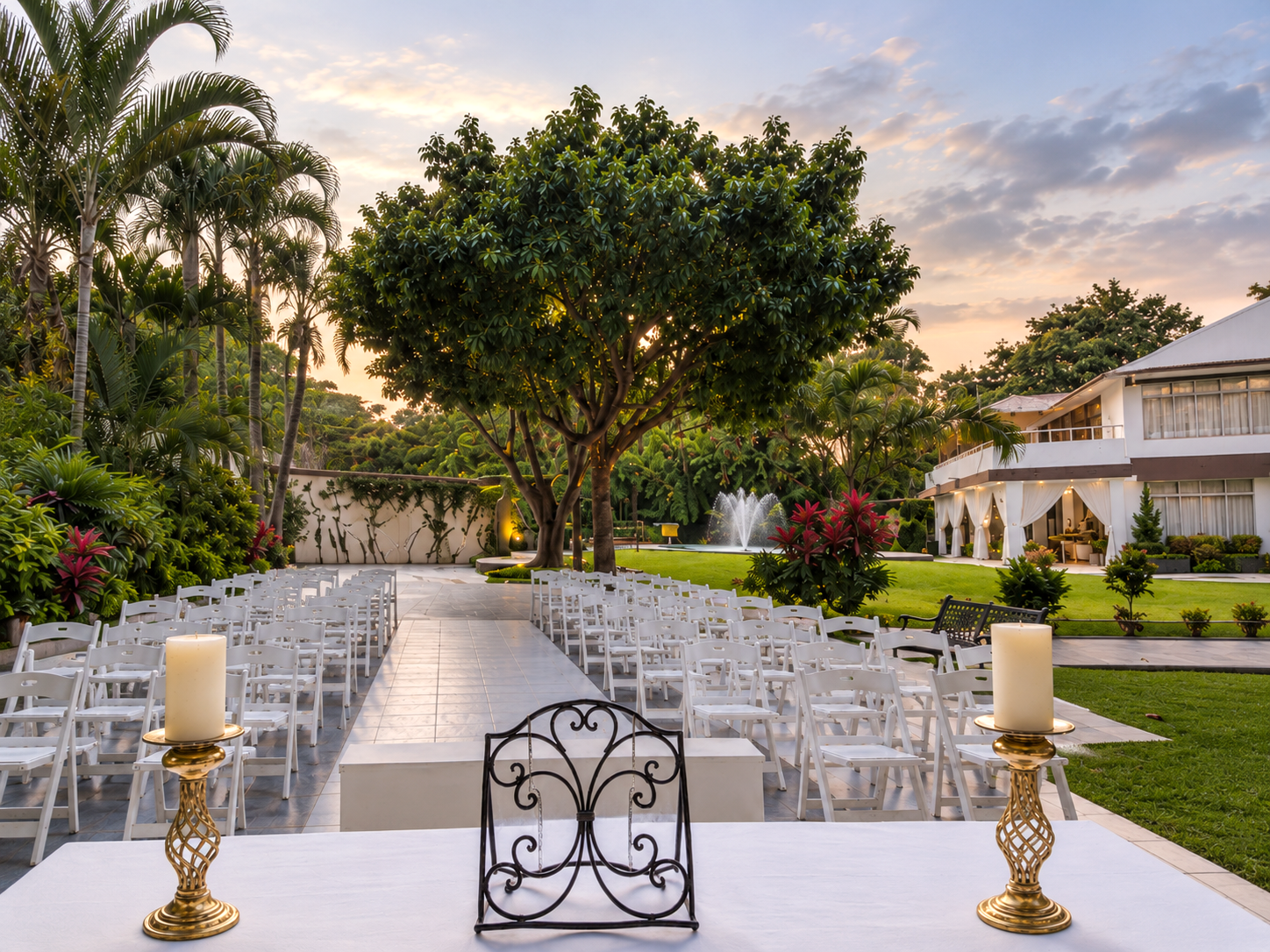 Pasillo de ceremonia con sillas blancas y fuente al atardecer en Jardín Allegra 55, Cuernavaca