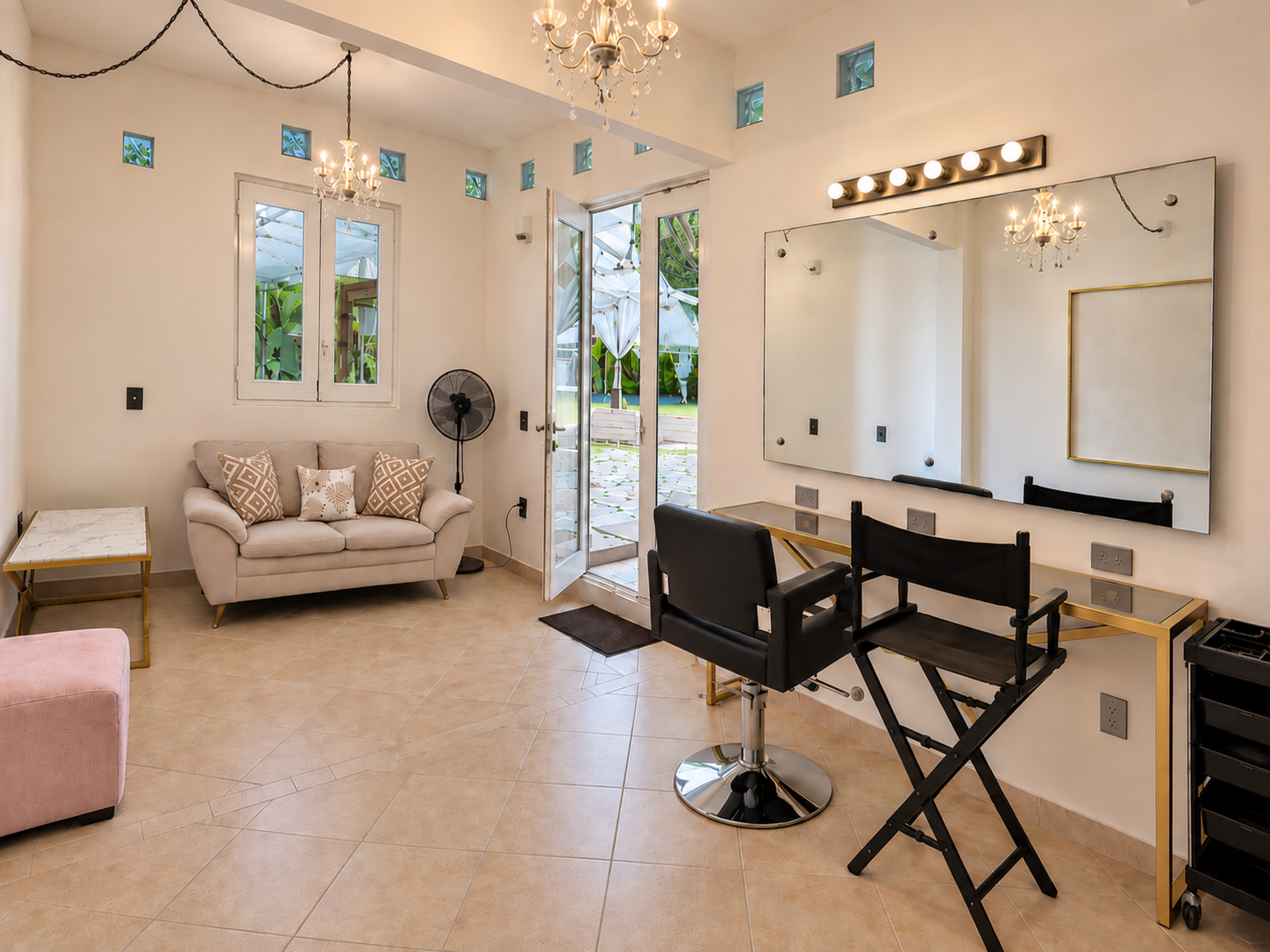 Sala del salón de estética con espejo, sillas de maquillaje y vista al jardín en Allegra 55, Cuernavaca