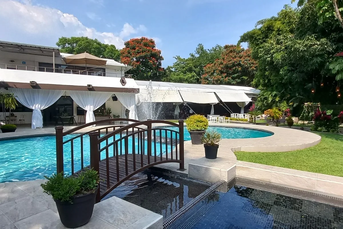 Vista del jardín, alberca y puente decorativo en Jardín Allegra 55.
