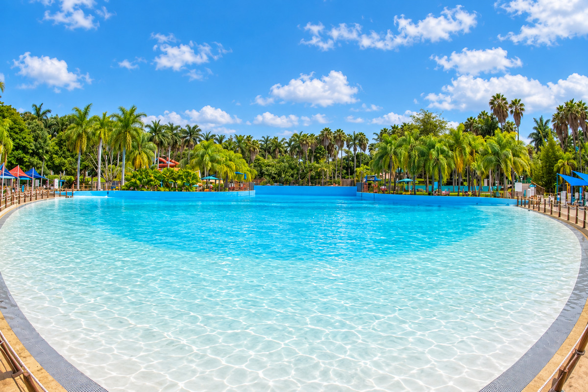 Wave pool at Hurricane Harbor Oaxtepec, Morelos, surrounded by palm trees and greenery.