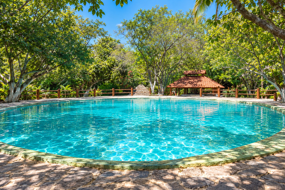 Turquoise pool surrounded by trees at Las Huertas swimming resort in Tlaquiltenango, Morelos.